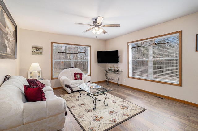 10412 W Woodrow Rd, Shelby, MI 49455 - living room featuring visible vents, baseboards, a ceiling fan, and wood finished floors