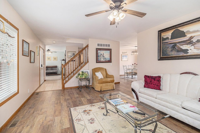 10412 W Woodrow Rd, Shelby, MI 49455 - living area with visible vents, a ceiling fan, wood finished floors, and stairs