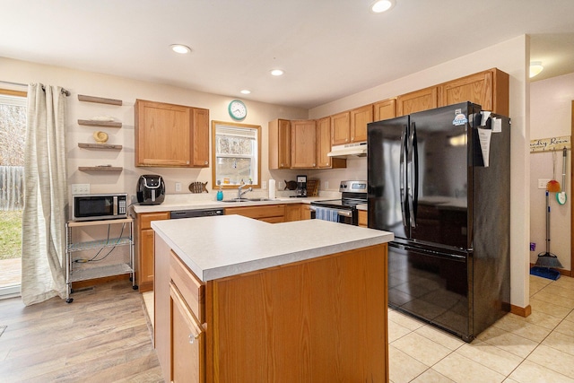 10412 W Woodrow Rd, Shelby, MI 49455 - kitchen with under cabinet range hood, light countertops, black appliances, and a healthy amount of sunlight
