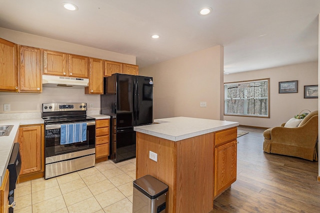 10412 W Woodrow Rd, Shelby, MI 49455 - kitchen with light countertops, under cabinet range hood, freestanding refrigerator, and stainless steel electric stove