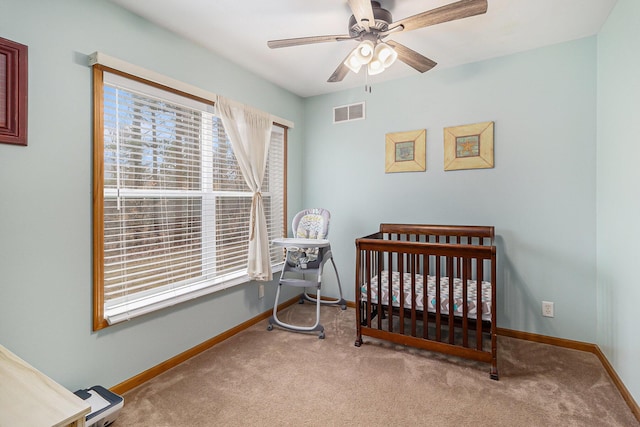 10412 W Woodrow Rd, Shelby, MI 49455 - carpeted bedroom with visible vents, baseboards, a nursery area, and ceiling fan
