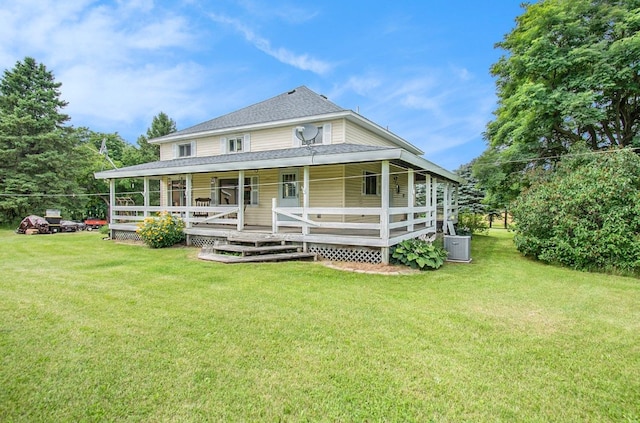 rear view of house with a porch, central AC, a shingled roof, and a lawn