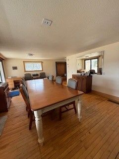 dining space featuring wood finished floors and a textured ceiling
