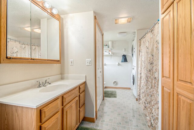 full bathroom featuring toilet, a textured ceiling, vanity, and baseboards