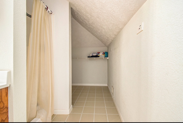 spacious closet featuring tile patterned flooring and lofted ceiling