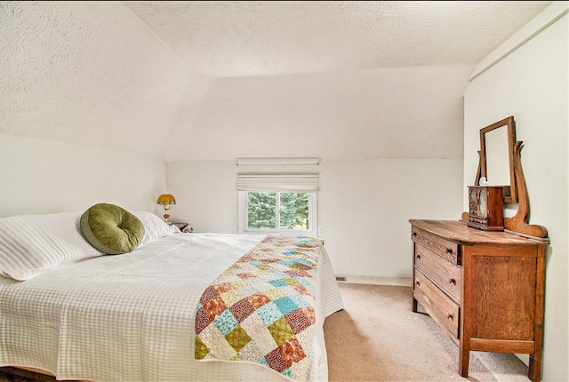 bedroom with light colored carpet, a textured ceiling, and vaulted ceiling