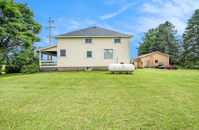 back of property with a yard and roof with shingles