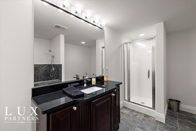 bathroom featuring a shower stall, visible vents, vanity, and baseboards