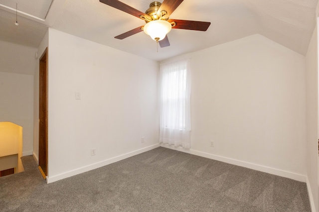 unfurnished room featuring dark colored carpet, baseboards, attic access, and ceiling fan