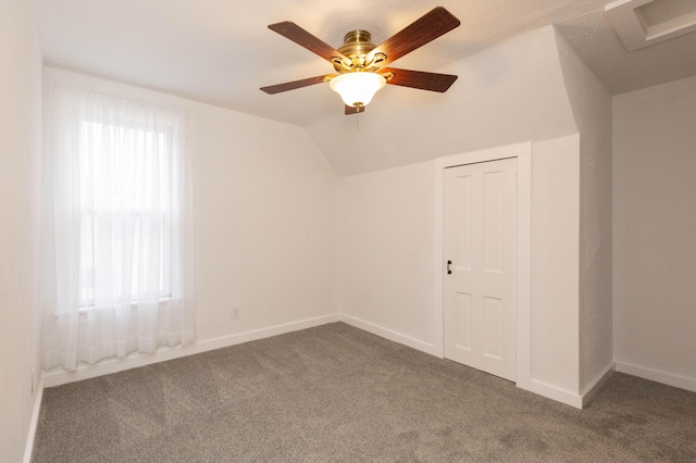 empty room featuring lofted ceiling, baseboards, and carpet floors