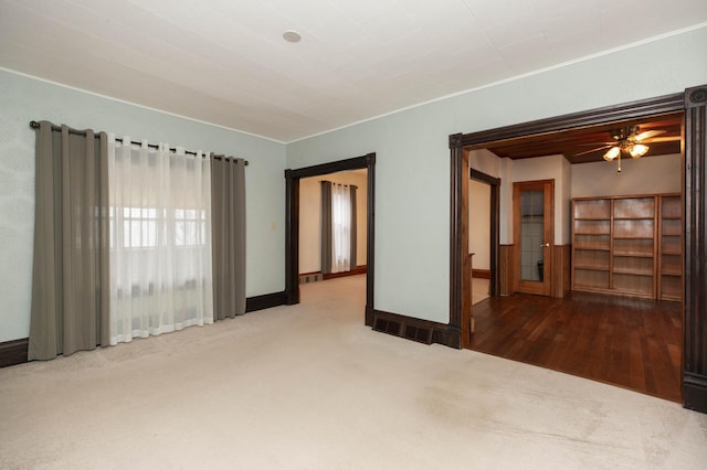 empty room with ceiling fan, visible vents, baseboards, and carpet