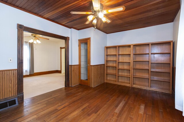 spare room featuring wainscoting, dark wood-style flooring, a ceiling fan, and visible vents