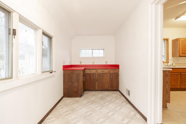 interior space featuring baseboards, a sink, and visible vents