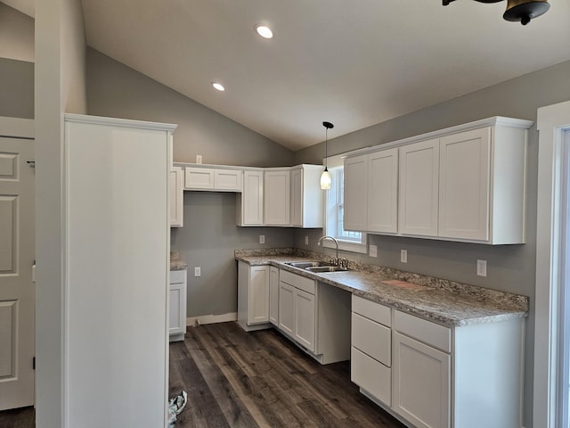 kitchen with a sink, white cabinetry, dark wood-type flooring, and lofted ceiling