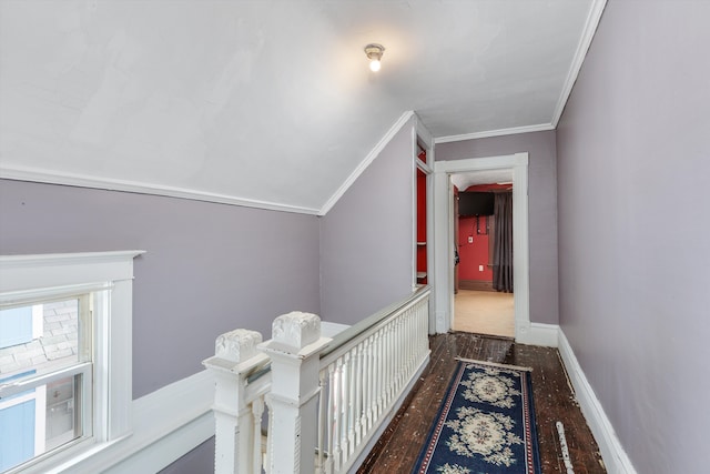hall with wood finished floors, ornamental molding, and an upstairs landing