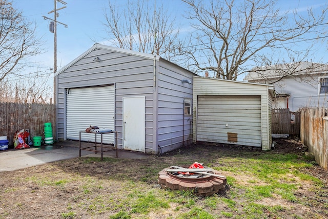 detached garage featuring fence