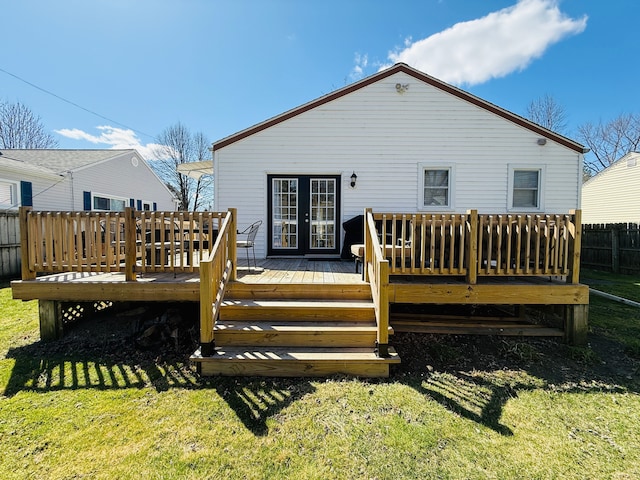 back of property featuring a wooden deck, french doors, a lawn, and fence
