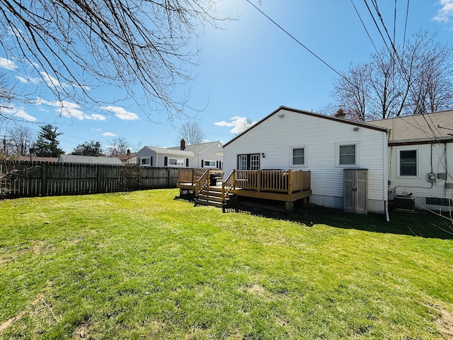 back of property featuring a wooden deck, a yard, and fence