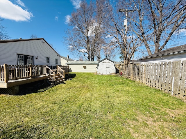 view of yard with a fenced backyard, an outdoor structure, french doors, a storage unit, and a deck