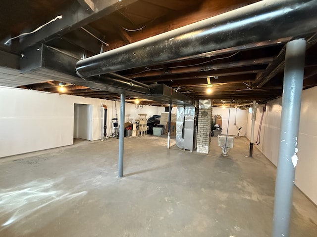 unfinished basement featuring heating unit