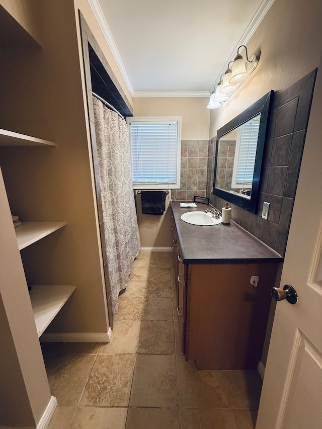 bathroom featuring baseboards, plenty of natural light, crown molding, and vanity