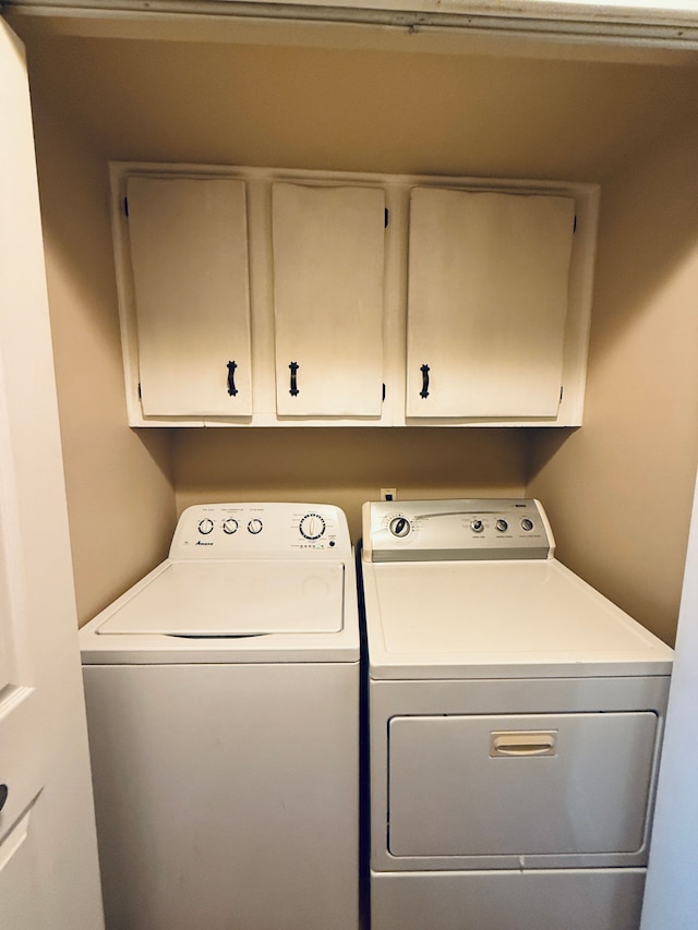 laundry room with separate washer and dryer and cabinet space