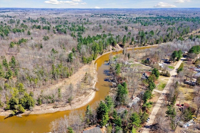 birds eye view of property featuring a wooded view and a water view