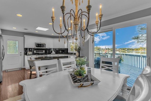 dining area featuring recessed lighting, a notable chandelier, dark wood-style floors, and a healthy amount of sunlight
