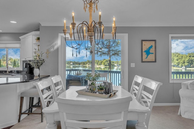 dining space with crown molding, an inviting chandelier, and light colored carpet