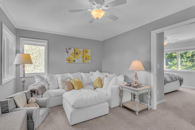 carpeted living area with crown molding, ceiling fan, and baseboards