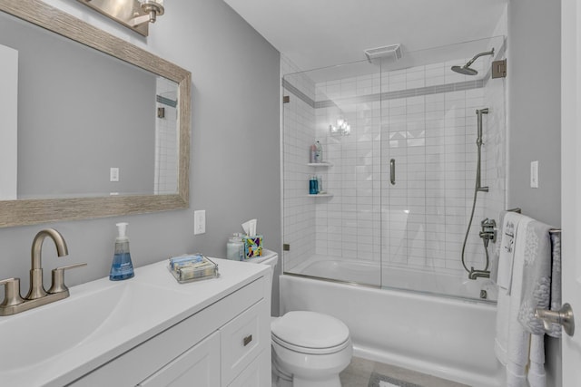 bathroom with toilet, vanity, visible vents, and bath / shower combo with glass door
