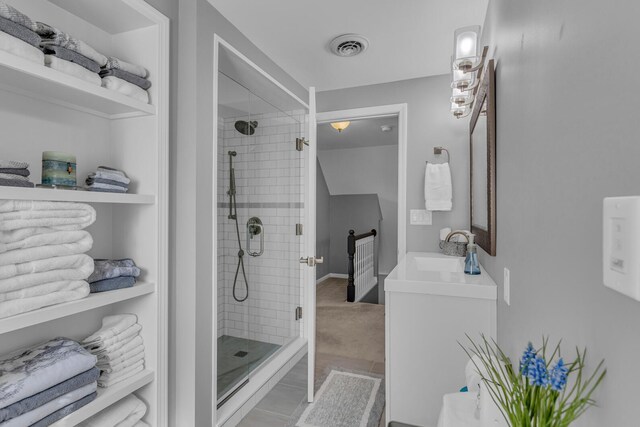 bathroom featuring vanity, visible vents, and a stall shower