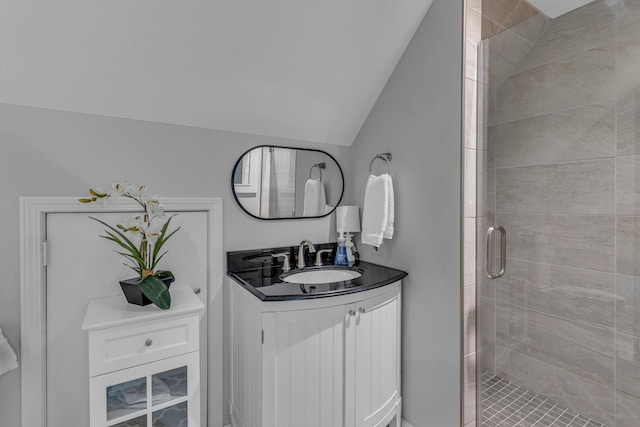 full bathroom with a stall shower, vaulted ceiling, and vanity