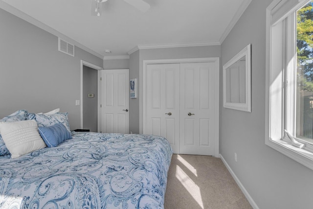 bedroom featuring a closet, baseboards, ornamental molding, light carpet, and visible vents
