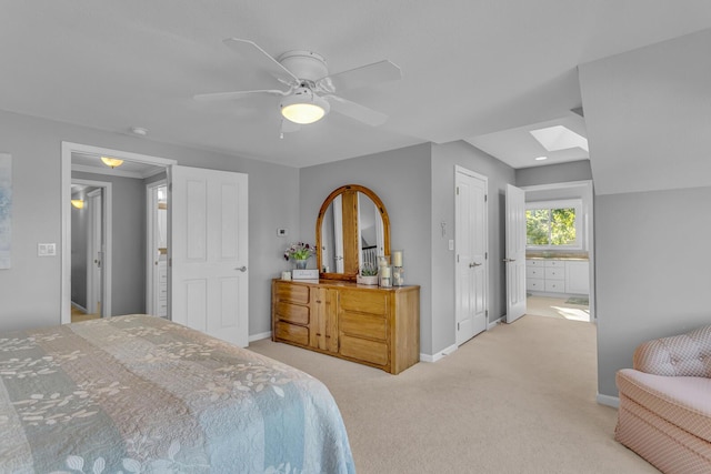 bedroom with ceiling fan, light colored carpet, baseboards, and a skylight
