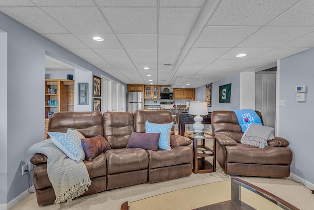 living room with baseboards, a drop ceiling, and recessed lighting