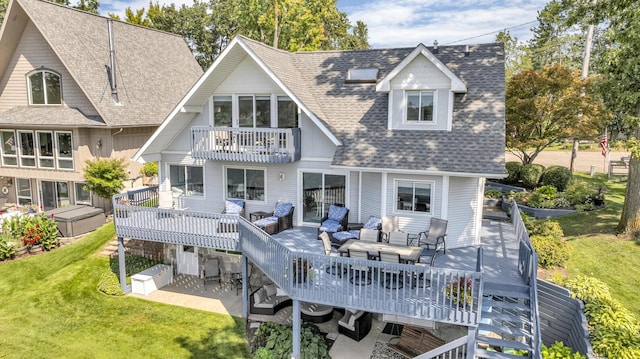 rear view of property featuring an outdoor hangout area, a yard, roof with shingles, a balcony, and a deck