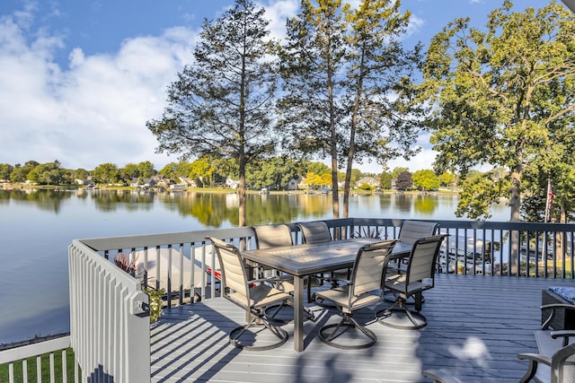 deck with a water view and outdoor dining space