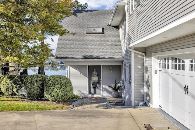 view of front of property featuring a water view and roof with shingles