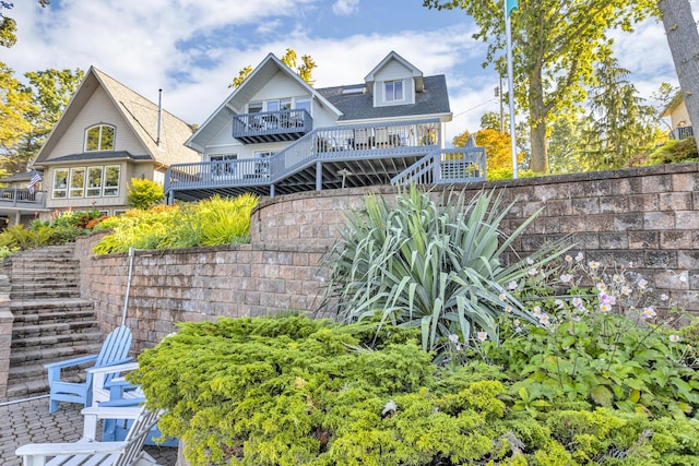 rear view of house featuring fence and stairs