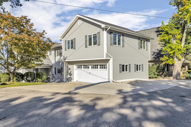 view of property exterior featuring an attached garage and driveway
