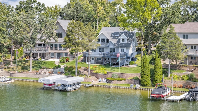 view of dock with a deck with water view, a lawn, boat lift, and stairs
