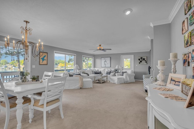 dining space featuring light carpet, baseboards, ceiling fan with notable chandelier, and ornamental molding