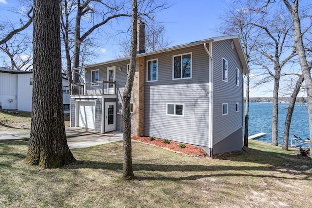 11672 Bradley Dr, Jerome, MI 49249 - exterior space featuring a water view, concrete driveway, a garage, and a lawn