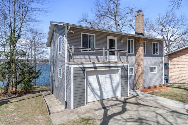 11672 Bradley Dr, Jerome, MI 49249 - rear view of property with a garage, a balcony, driveway, and a chimney
