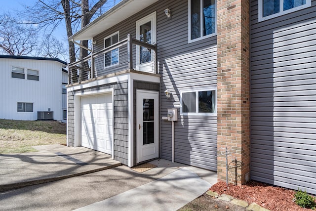 11672 Bradley Dr, Jerome, MI 49249 - property entrance featuring concrete driveway, a garage, and central AC