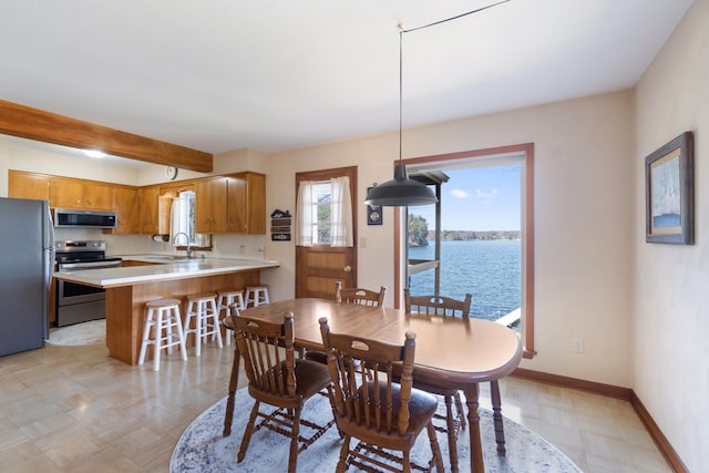 11672 Bradley Dr, Jerome, MI 49249 - dining space with a water view, beam ceiling, baseboards, and light floors