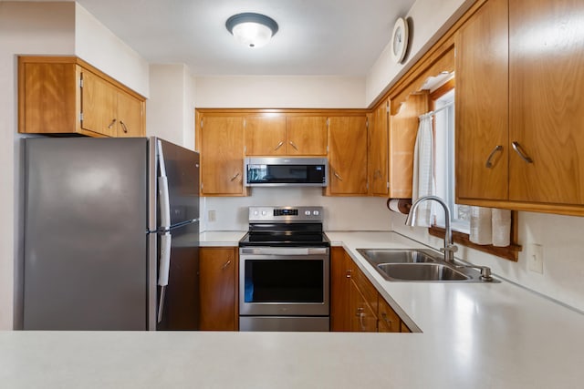 11672 Bradley Dr, Jerome, MI 49249 - kitchen with light countertops, brown cabinets, appliances with stainless steel finishes, and a sink