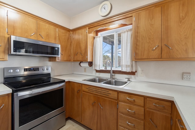 11672 Bradley Dr, Jerome, MI 49249 - kitchen with a sink, light countertops, appliances with stainless steel finishes, and brown cabinets