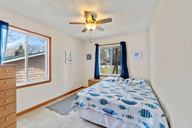 11672 Bradley Dr, Jerome, MI 49249 - bedroom featuring multiple windows, baseboards, a ceiling fan, and light floors